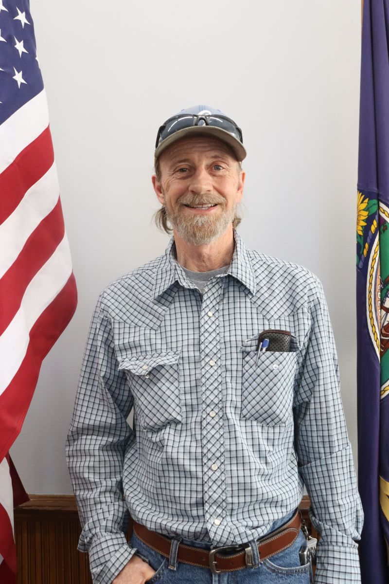 Photo of Maintenance Worker Danny Gamblin in front of American and Kansas flags