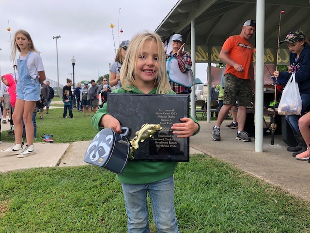 Photo of fishing derby contestant with award