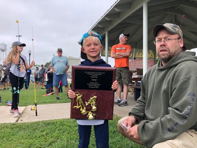 Photo of fishing derby contestant with award