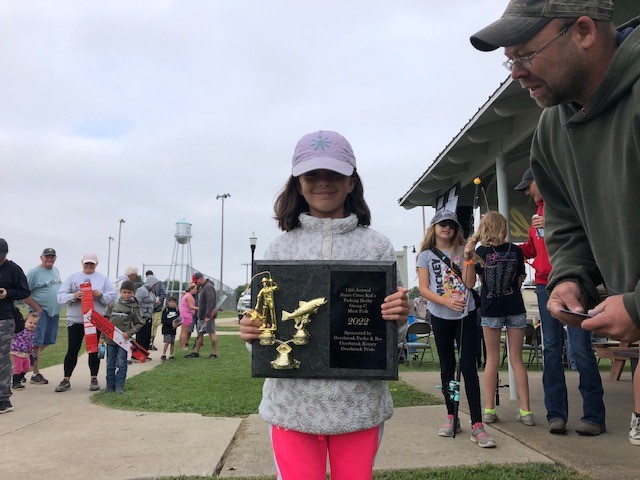 Photo of fishing derby contestant with award